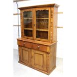 An early 20th century pine dresser, stepped frieze above two glazed doors,