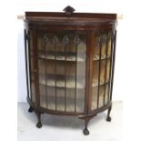 An Edwardian bow-front display cabinet with two interior shelves,