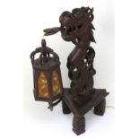 An early 20th century Oriental hardwood lamp in the form of a dragon with serpent tongue suspending