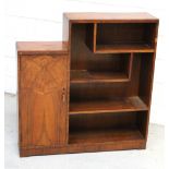 An Art Deco style walnut bookcase with stepped shelves and one cupboard to one side, on plinth base,