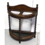 An early 20th century oak hall umbrella stand on wrythen supports,