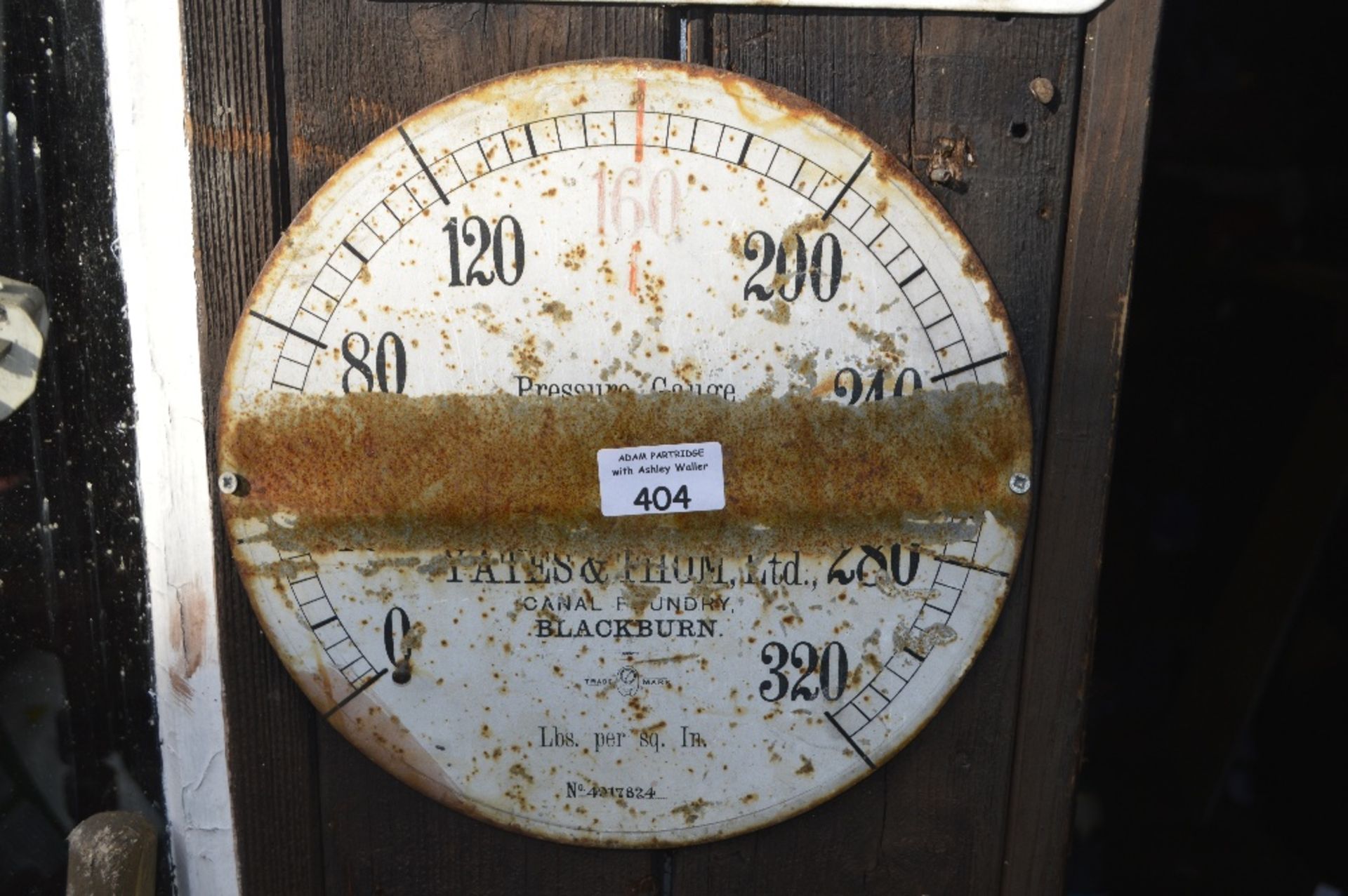 A wall plaque modelled as a pressure gauge, inscribed 'Yates & Thom Ltd.