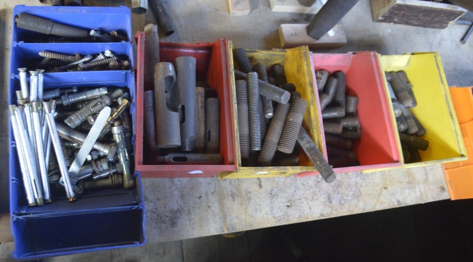 A large quantity of threaded studs and miscellaneous drill accessories.