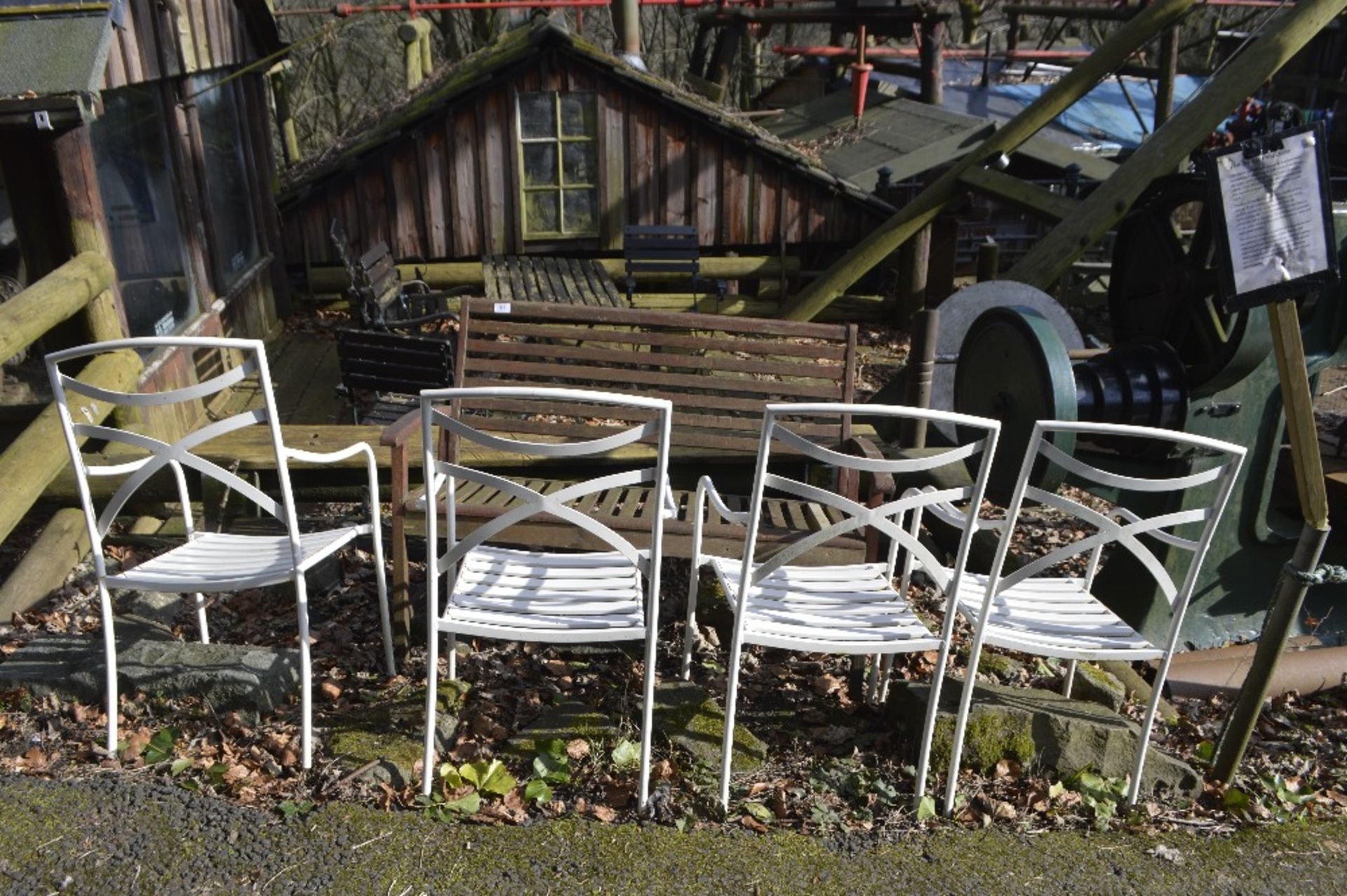 A wooden bench and four white chairs (5).