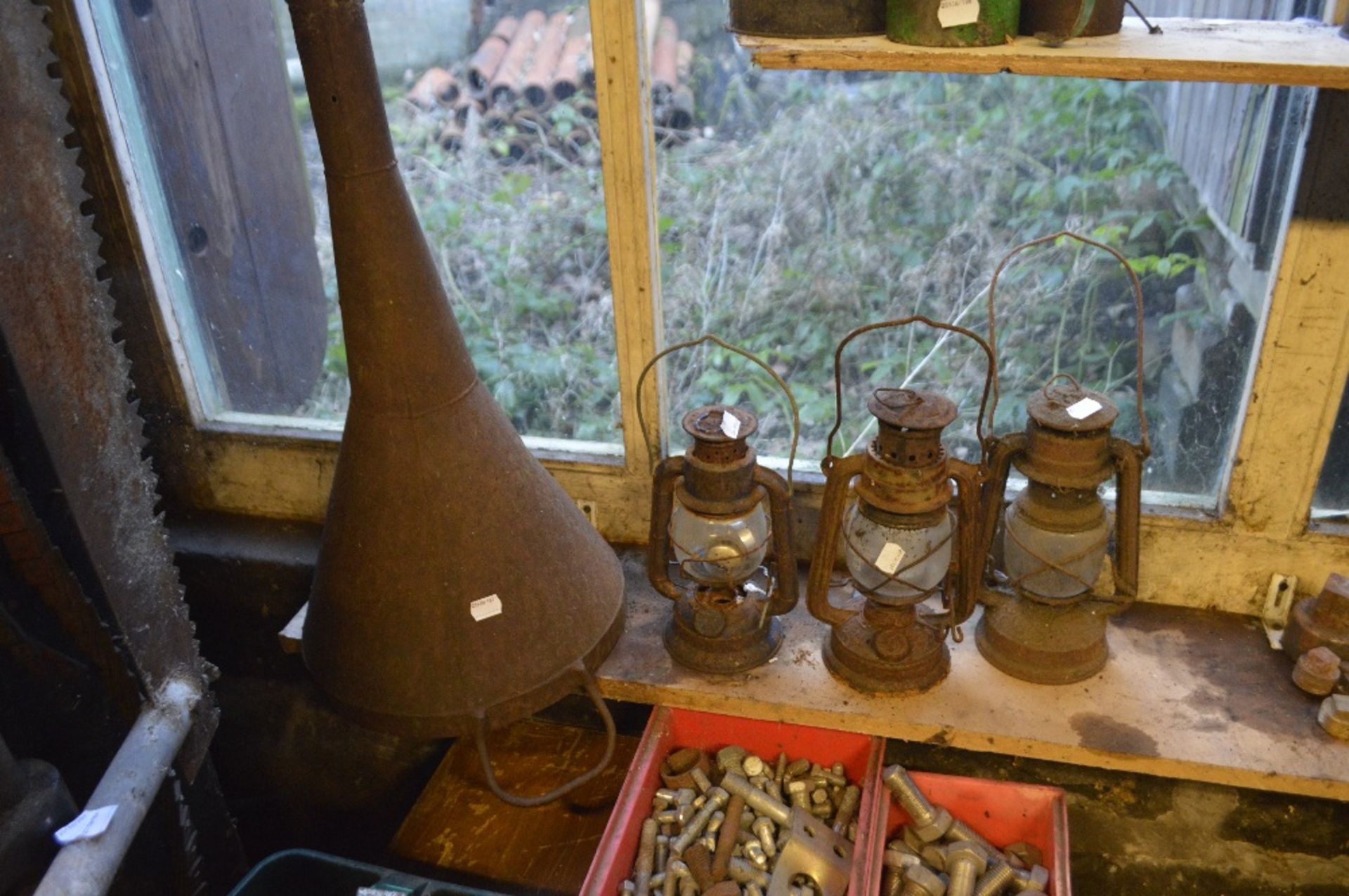 Three storm lanterns and a large funnel (4).