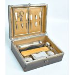 A faux leather vanity box with compartments containing metal lidded jars, clothes brush, comb, and