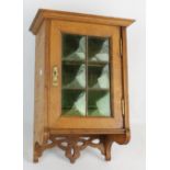 A 20th century oak smokers' cabinet a door with leaded green glass, width approx. 33cm.