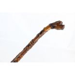 A late 19th century walking cane with dog head pommel, the card shaft depicting humorous animal