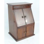 An Edwardian mahogany and inlaid radio cabinet, the sloped front with pair of hinged doors enclosing