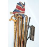 A collection of walking sticks and canes including a horn dogs head handled silver collared example,