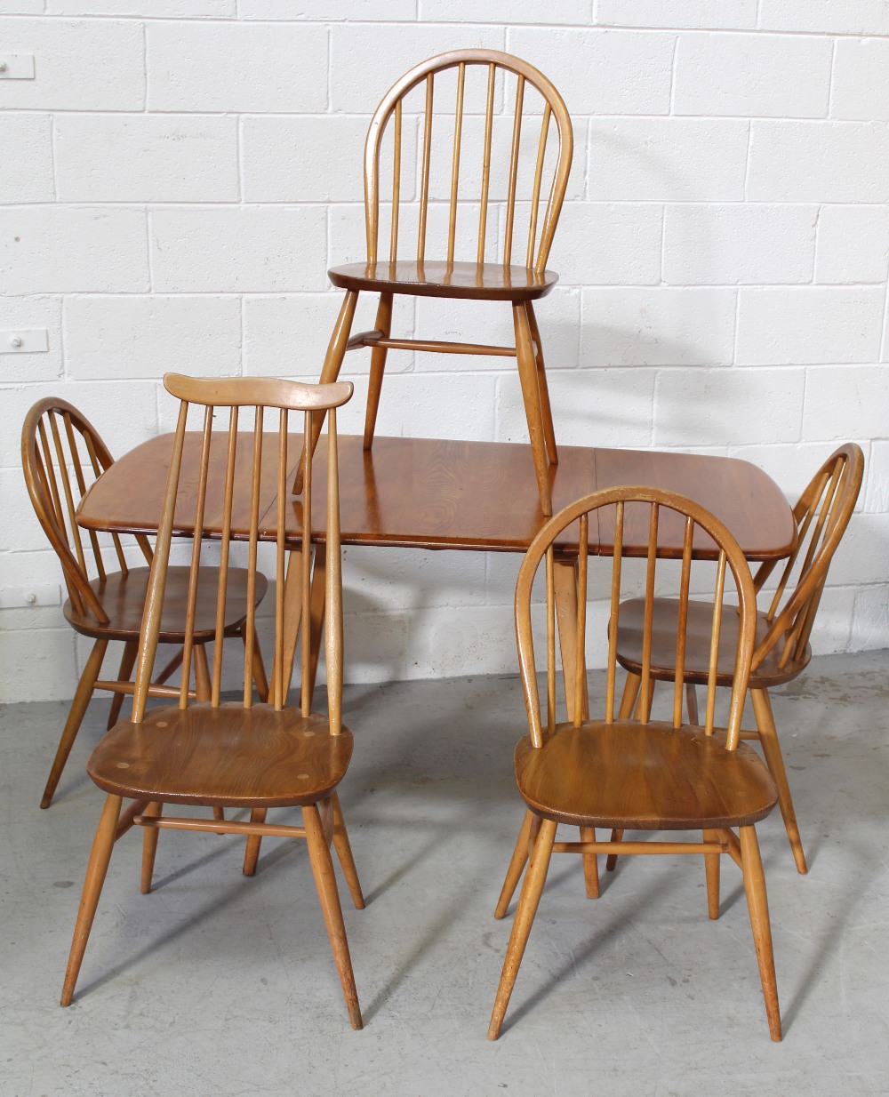 An Ercol rectangular drop-leaf dining table on tapering legs,