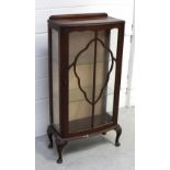 A 1940s walnut display cabinet with cartouche-shaped glazing bars to the door enclosing two glass