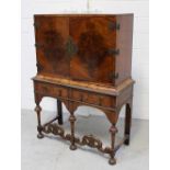 An early 20th century walnut cabinet on stand, with pair of doors above above two drawers,
