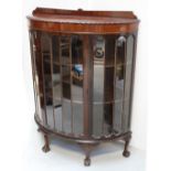 A mid-to-late 20th century mahogany display cabinet with serpentine break-front glazed centre