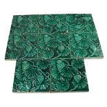 A set of eight Minton green glazed tiles with floral decoration in relief,