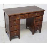 An oak kneehole twin-pedestal desk with inset leather top above two long and three six short