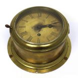 A brass-cased ship's bulk head clock, the circular dial set with Roman numerals, diameter 14cm,