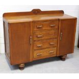 A 1950s oak sideboard/cabinet, central bank of four drawers flanked by cupboards,