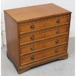 A low teak reproduction chest of four drawers with circular loop handles, on plinth base,