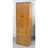 A modern pale oak twin-door cupboard with six-section interior above six drawers of varied size,