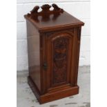 An Edwardian mahogany bedside cabinet with carved panel to single door, on plinth support,