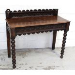 An early 20th century oak hall table with carved back frieze on turned supports, length 106cm.