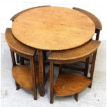 A retro oak nest of five tables comprising a large circular table and four small triangular tables.