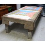 A very large wooden flower bed converted to a table with an industrial metal clad support and