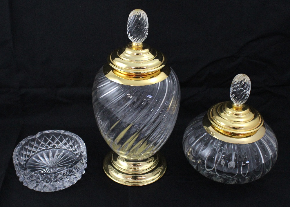 A metal-mounted large glass jar and cover with yellow coloured metal mounts on footed base,