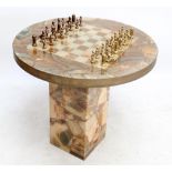 An onyx and resin games table, height 79cm, and chess set.