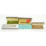 Five boxed pens and sets comprising Tiffany & Co sterling silver ballpoint with golf ball detail,