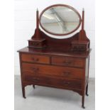 An Edwardian mahogany dressing chest with oval mirror and jewellery boxes above a two-over-two