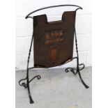 An Arts and Crafts wrought iron and hammered brass fire screen with embossed stylised decorative