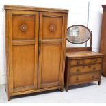 An early-to-mid 20th century oak two-drawer compactum wardrobe with floral and keywork frieze and