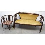 An Edwardian mahogany inlaid two-seater settee on tapering supports,