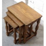 A nest of three oak tables on turned tapering supports and stretchers.