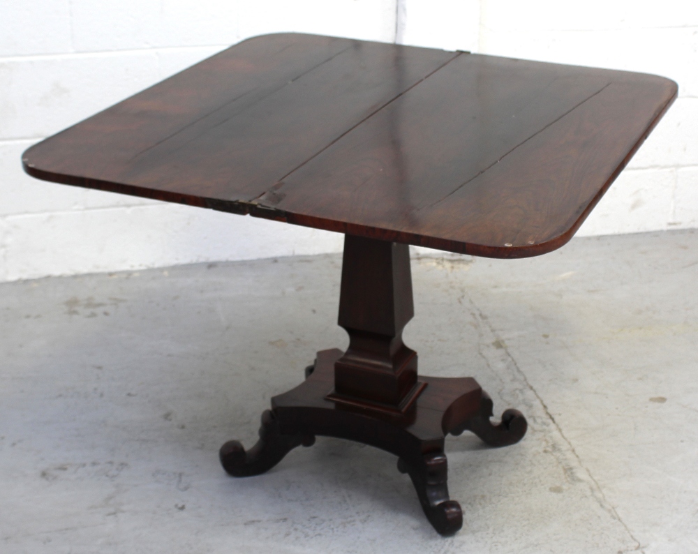 A Victorian rosewood fold-over rectangular tea table on spreading rectangular column above