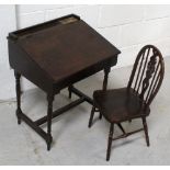 An early 20th century oak child's desk with ceramic ink pots and brass covers,