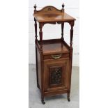 An Edwardian rosewood Arts and Crafts coal bin with carved central door above turned supports to