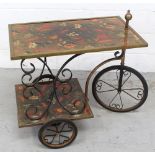 A 1960s kitsch mixed metal tea trolley with floral material beneath Perspex covering on tricycle