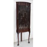 A reproduction mahogany freestanding corner cupboard of large proportions on cabriole supports,