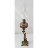 A Victorian brass and amethyst glass oil lamp, the base modelled as a seated woman, height 71cm.