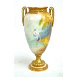 A Royal Worcester hand painted gilt heightened twin handled vase decorated with a stork standing in