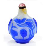 A Chinese blue and white carved overlay glass snuff bottle of flat globular form decorated with