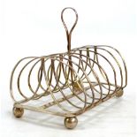 A William IV hallmarked silver six division toast rack with central loop handle, on four ball feet,