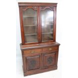 A late Victorian walnut glazed bookcase on cupboard, width 120cm.