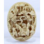 A 19th century Chinese Export oval ivory plaque finely carved in relief with figures at the table