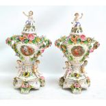 A pair of early 20th century Continental floral encrusted and transfer decorated figural urns with