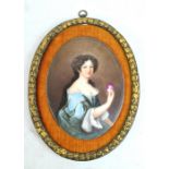 A 19th century Continental oil on porcelain half-length portrait depicting a lady holding a cameo,