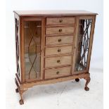 An Edwardian mahogany display cabinet with six central drawers flanked by glazed doors,